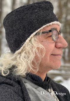 an old man with glasses and a hat on in the snow looking off into the distance