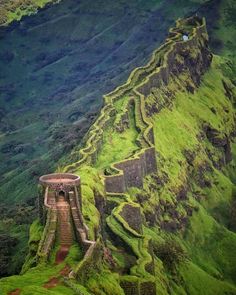 the great wall of china is covered in green mossy grass and has stairs leading up to it