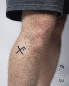 a man with a cross tattoo on his leg