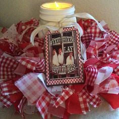 a candle that is sitting on top of some red and white ribbons with the words happy valentine's day written on it