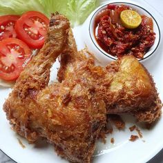 fried chicken with tomato and lettuce on a plate next to some ketchup