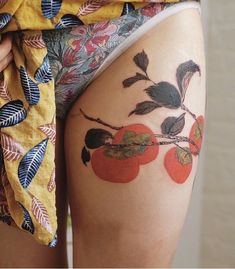 a close up of a person's legs with tattoos on them and fruit painted on the thighs