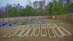 an unfinished garden area in the middle of a fenced yard with lots of wood