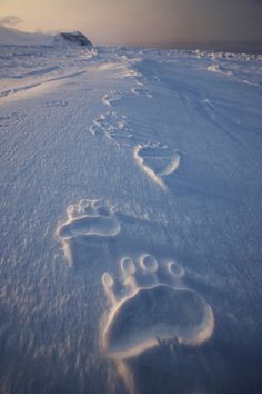 two footprints in the snow near one another