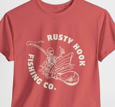 Rustic fishing shirt perfect for outdoor enthusiasts and nature lovers. This unisex heavy cotton tee provides a comfortable and relaxed fit, making it suitable for casual wear. The design gives off a laid-back and rugged vibe, ideal for fishing trips or outdoor adventures. This tee is made with high-quality fabric for durability and features a tear-away label for scratch-free comfort. Product features - Shoulder tape for stability and prevent stretching - Ribbed knit collar without seam for elas Angel T Shirt, Fishing Gift, Outdoor Shirt, Camping Outfits, Hiking Shirts, Vintage Fishing, Fishing Gifts, Fishing T Shirts, Gifts For Nature Lovers