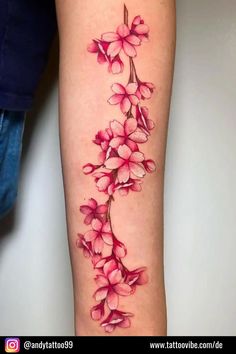 a woman's leg with pink flowers tattooed on the side of her thigh and arm