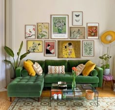 a living room with green couches and pictures on the wall