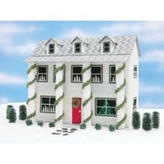 a paper model of a white house with green ivys on the windows and door