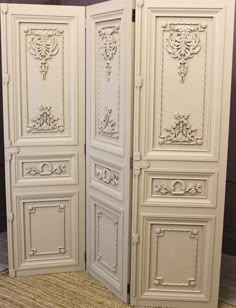 the room divider is painted white and has ornate carvings on it's doors