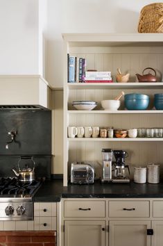 the kitchen is clean and ready for us to use it's shelves are filled with dishes