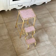 three tiered stools with pink carpet in front of an oven and countertop