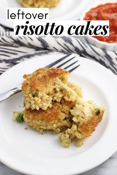 two white plates topped with crab cakes next to a bowl of tomato sauce and a fork