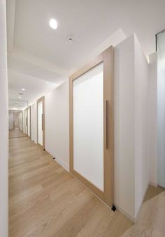 an empty hallway with white walls and wooden doors