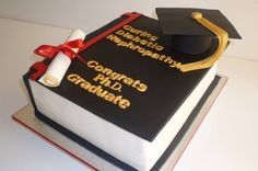 a graduation cake that is decorated with a book and mortare on top of it