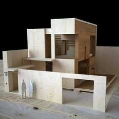 two people standing in front of a model of a house