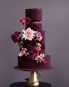 a three tiered purple cake with flowers on top