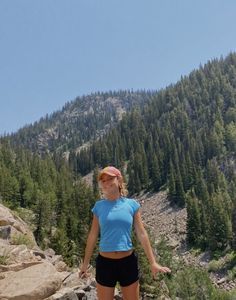 a woman standing on top of a rocky hillside