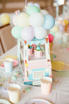 an ice cream stand is decorated with balloons and confetti for a birthday party