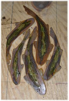 five fish are laying on a wooden surface