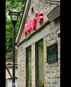 a brick building with pink letters on the front