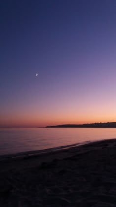 the sun is setting on the beach with no clouds in sight, and it's still dark