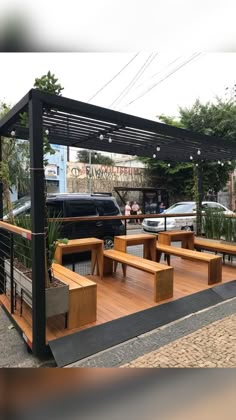 an outdoor seating area with wooden benches and plants