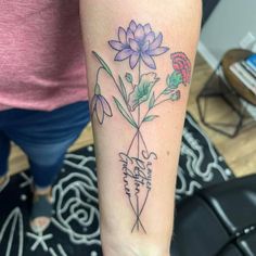 a woman with a tattoo on her arm has a flower in the middle of it