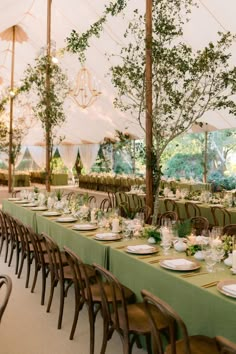 an outdoor tent with tables and chairs set up for a formal dinner or party event