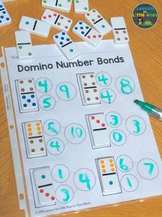 the domino number bonds game is being played on a table with markers and pencils