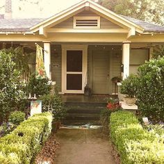 a house with hedges and bushes around it