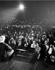 a man sitting in front of a crowd at a concert