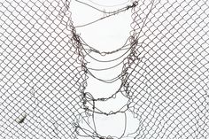 a chain link fence with barbed wire hanging from it's sides in front of a white background