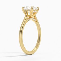 a yellow gold ring with an oval cut diamond in the center and side stones on each side