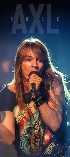 a man with long hair and piercings holding a microphone to his mouth while standing on stage