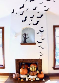 a living room filled with lots of pumpkins on top of a mantle covered in bats