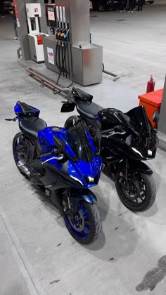 two motorcycles parked next to each other at a gas station