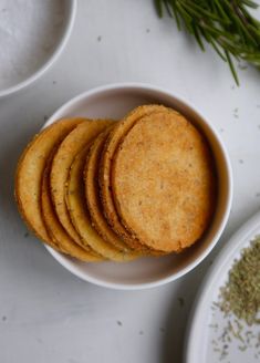 a white bowl filled with crackers on top of a table next to other dishes