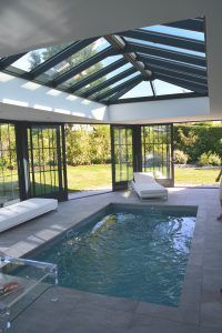 an indoor swimming pool surrounded by glass walls