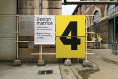 a yellow sign sitting on the side of a road next to a tall brick building