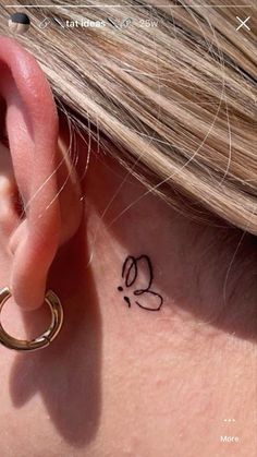 a close up of a person's ear with a small tattoo on it