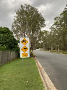 a street sign on the side of a road with trees in the backgroud