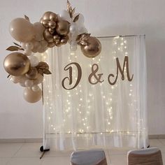 balloons and chairs are set up in front of a backdrop with the word d & m on it