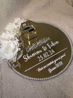 a personalized wedding cake plate with flowers and a ring box on the table top