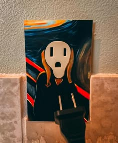 a toilet paper holder with a painting of a woman's face on the wall