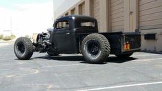 an old black truck parked in front of a building