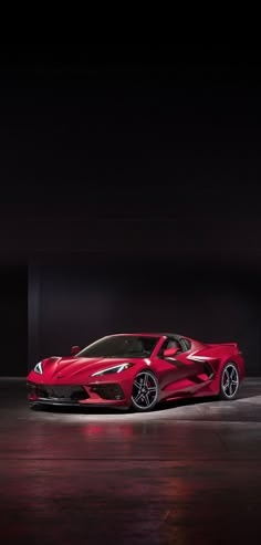 a red sports car parked in a dark room