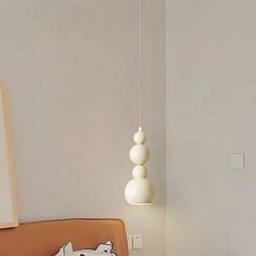 a bed sitting next to a wall with a lamp hanging from it's side