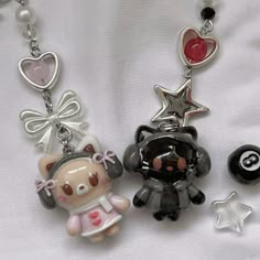 three key chains with charms attached to them on a white cloth covered bedding area