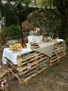 an outdoor table set up with food and decorations