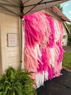 pink and white streamers hanging from the side of a building